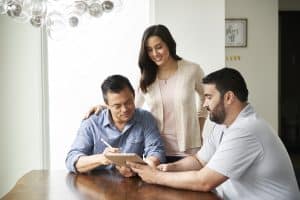 husband and wife reviewing information with an advisor on a tablet
