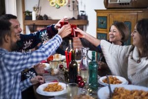 family toasting drinks at the dinner table during christmas